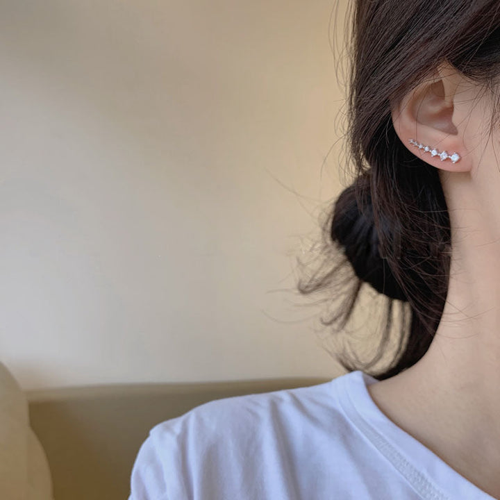 "Sju-stjärniga stiftörhängen med kristaller i guld, eleganta accessoarer för kvinnor, glänsande och sofistikerad design."