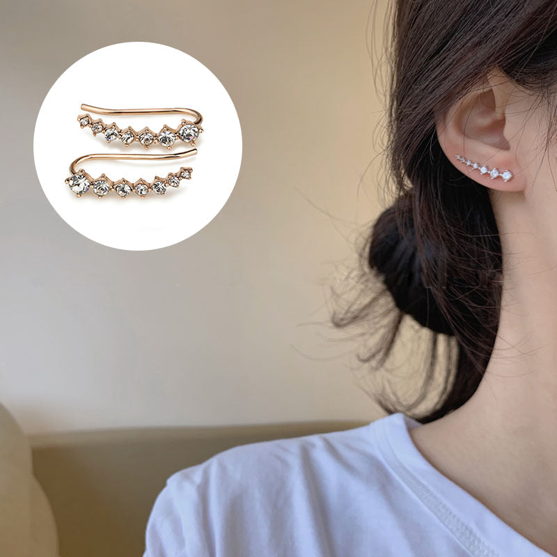 "Sju-stjärniga stiftörhängen med kristaller i guld, eleganta accessoarer för kvinnor, glänsande och sofistikerad design."