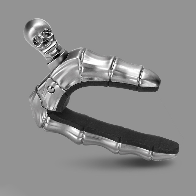 Skalleformad gitarrcapo i metall med unik design, perfekt för akustiska och elektriska gitarrer, finns i flera färger.