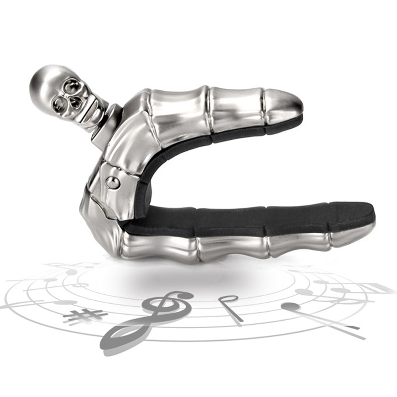 Skalleformad gitarrcapo i metall med unik design, perfekt för akustiska och elektriska gitarrer, finns i flera färger.