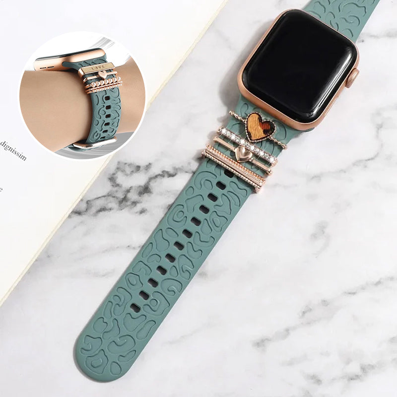 "Smartklockband med dekorativa metallringar i gyllene leopardmönster och roséguldstjärnor, elegant stilaccessoar."