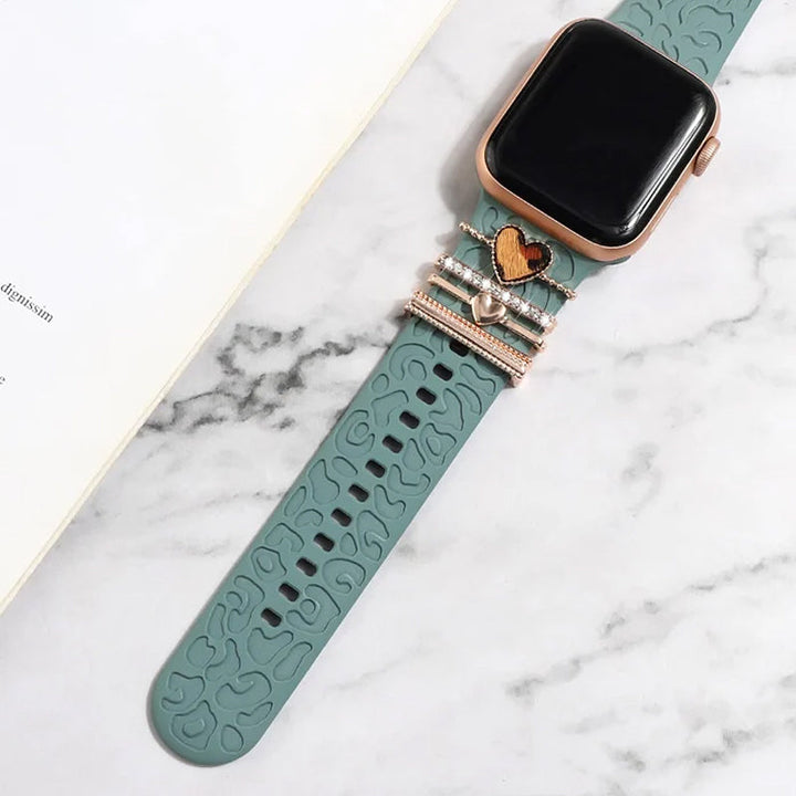 "Smartklockband med dekorativa metallringar i gyllene leopardmönster och roséguldstjärnor, elegant stilaccessoar."