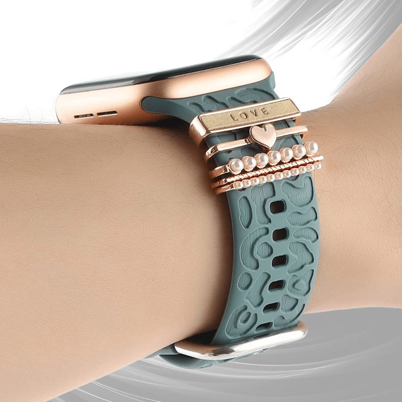 "Smartklockband med dekorativa metallringar i gyllene leopardmönster och roséguldstjärnor, elegant stilaccessoar."