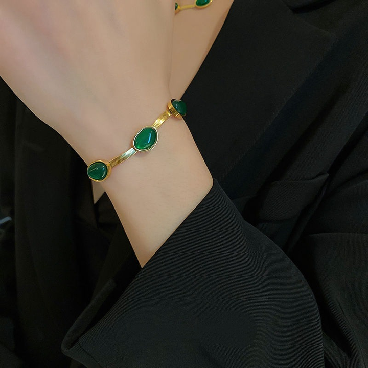 "Smycke i titanstål för kvinnor, smaragdberlock: elegant halsband och armband i grönt för stil och sofistikation."
