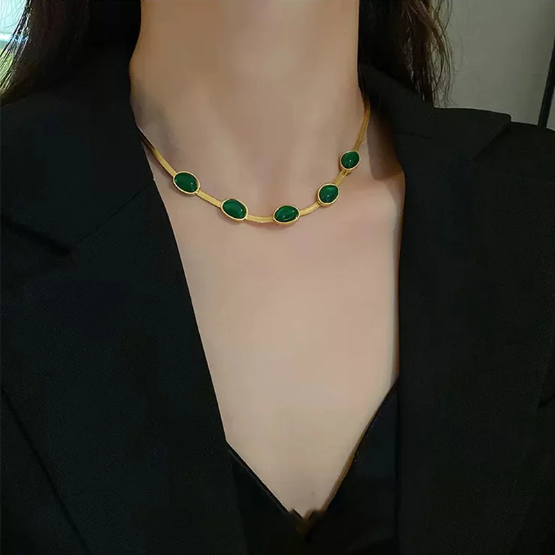 "Smycke i titanstål för kvinnor, smaragdberlock: elegant halsband och armband i grönt för stil och sofistikation."