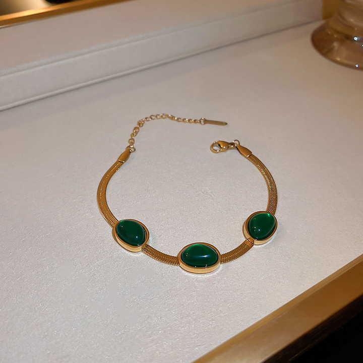 "Smycke i titanstål för kvinnor, smaragdberlock: elegant halsband och armband i grönt för stil och sofistikation."
