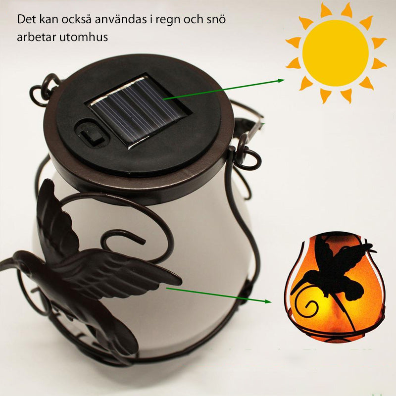 "Solar trädgårdslampa med fjärilsdekor, bronsfinish, ger magiskt ljus och avkoppling i din utomhusmiljö."