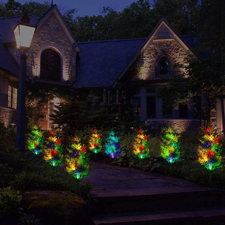 "Solcellsdriven RGB trädgårdsbelysning för jul, naturinspirerad design med cypress- och tallbladseffekt, magisk atmosfär."