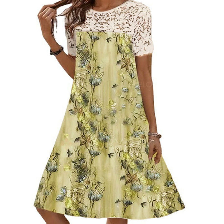 "Sommarlång klänning med spets, framifrån, för kvinnor. Elegant, feminin silhuett med blommigt mönster och rund hals."