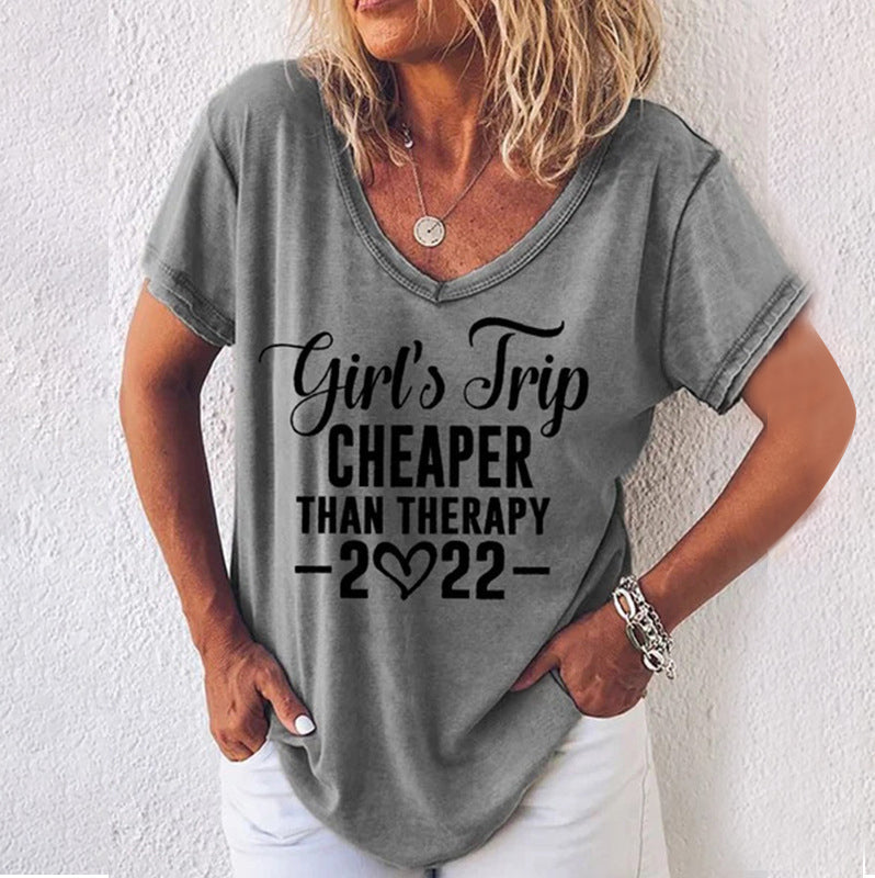 "Somrig damt-shirt med V-ringning, korta ärmar och subtilt engelskt tryck i mjukt, stretchigt polyestertyg."