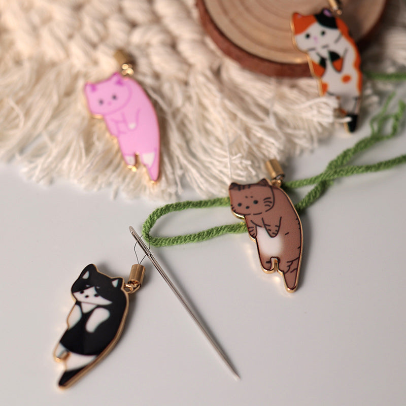 "Söt katt nålgängare i olika färger för enkel nålträdning, funktionell och stilfull accessoar för broderi."