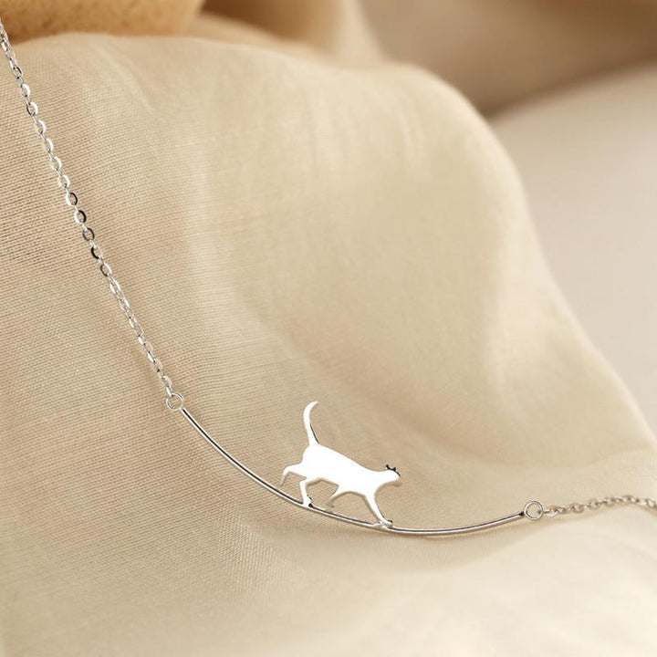"Sött halsband med gående katt i guld och silver, perfekt för alla åldrar. Kvinnors accessoar som utstrålar charm och elegans