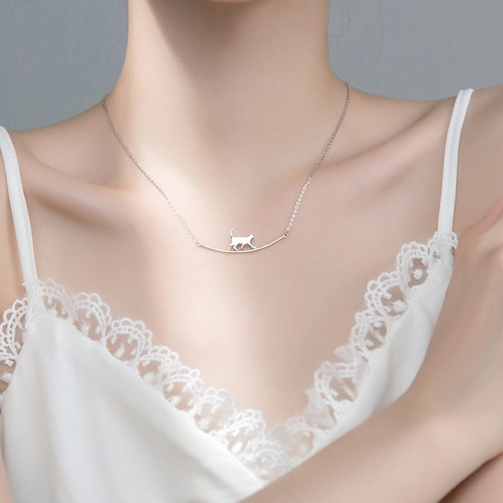 "Sött halsband med gående katt i guld och silver, perfekt för alla åldrar. Kvinnors accessoar som utstrålar charm och elegans