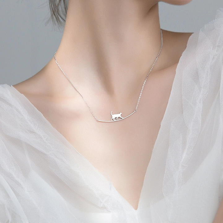"Sött halsband med gående katt i guld och silver, perfekt för alla åldrar. Kvinnors accessoar som utstrålar charm och elegans