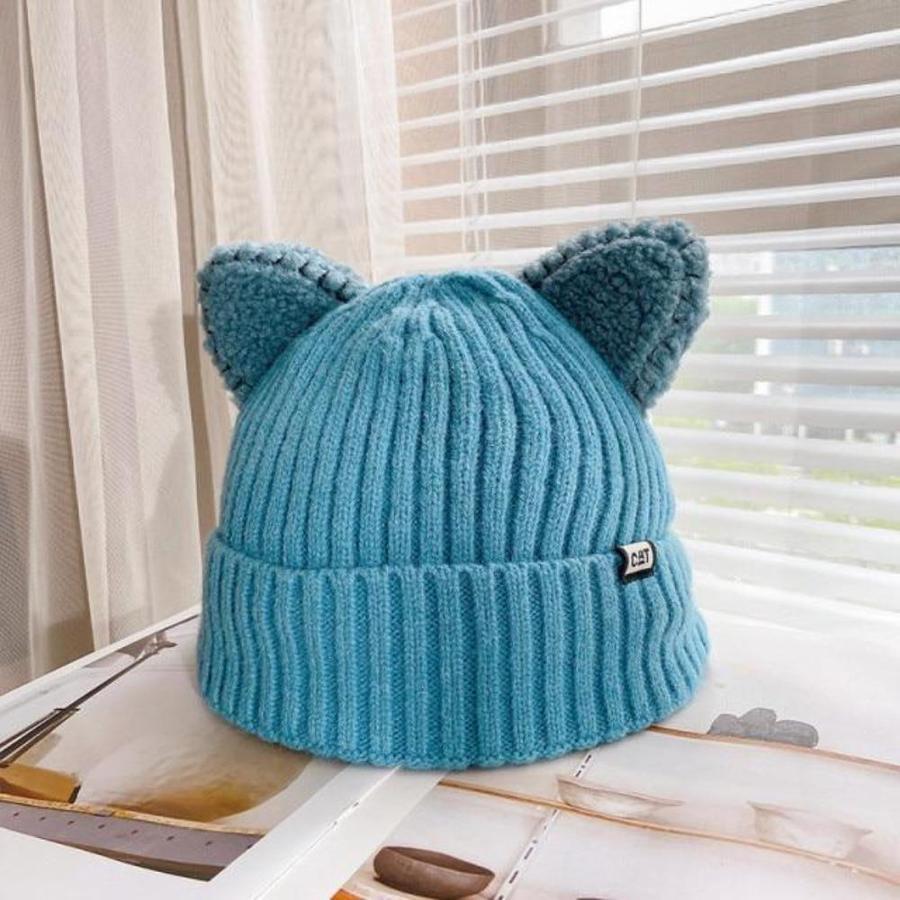 "Stickad unisex vintermössa med 3D-kattöron i mjukt material, ses i olika färger för en lekfull vinterstil."