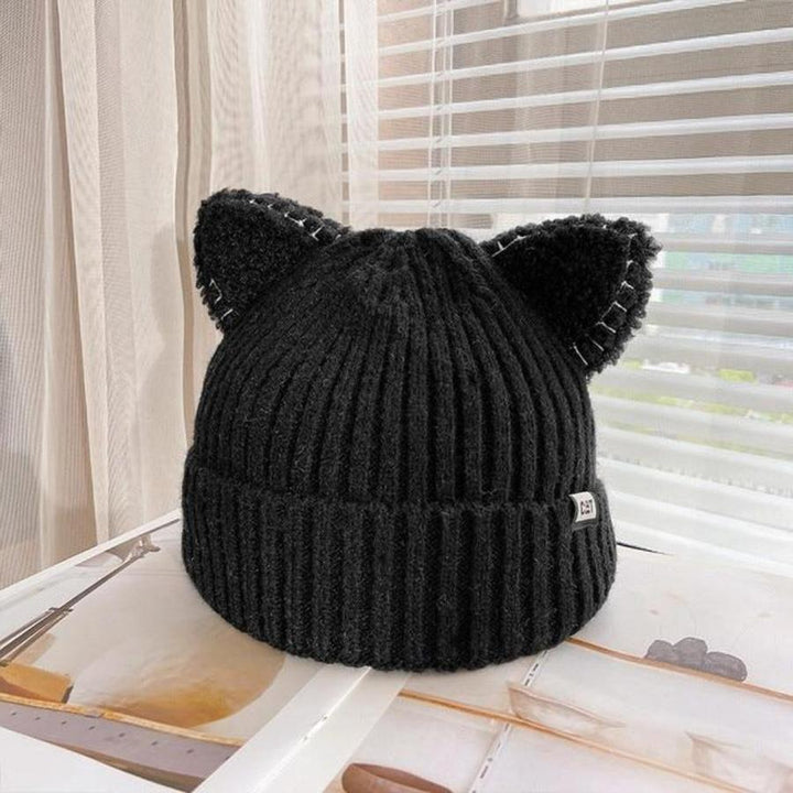"Stickad unisex vintermössa med 3D-kattöron i mjukt material, ses i olika färger för en lekfull vinterstil."