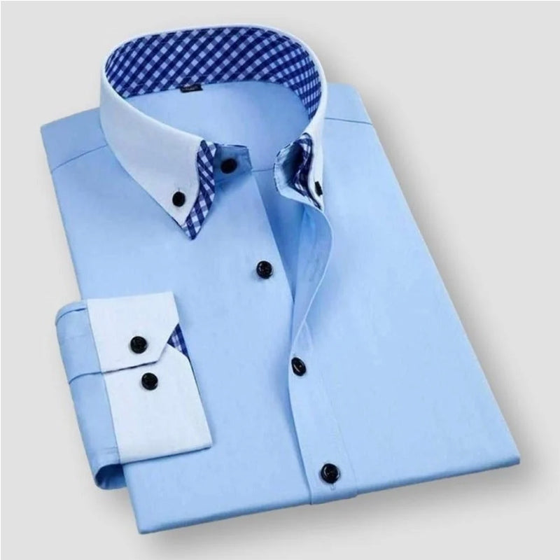 Närbild på den klassiska herrskjortans krage med kontrasterande rutigt foder som lyfter den skräddarsydda designen, en casual men ändå stilren detalj.