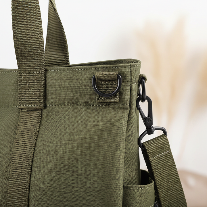 Kvinna bär elegant ToteMax axelremsväska, damväska i urban miljö. Perfekt för laptop och daglig användning.