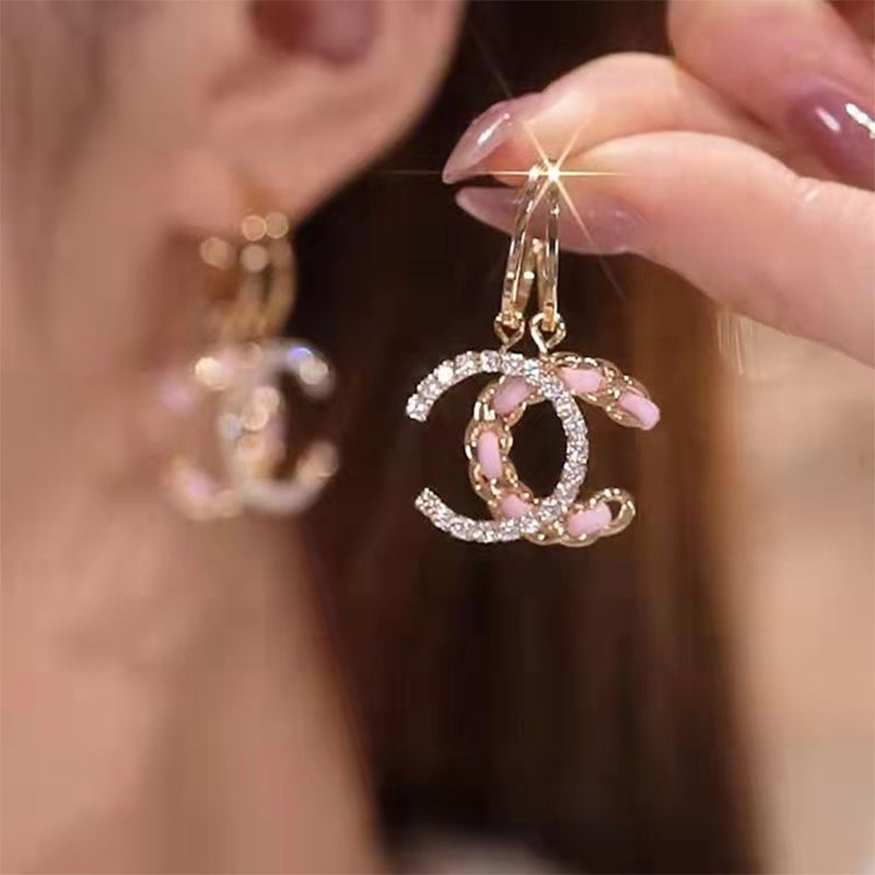 "Stilrena kvinnors silverörhängen med glittrande kristaller i dubbel 'C' design, eleganta och tidlösa accessoarer."