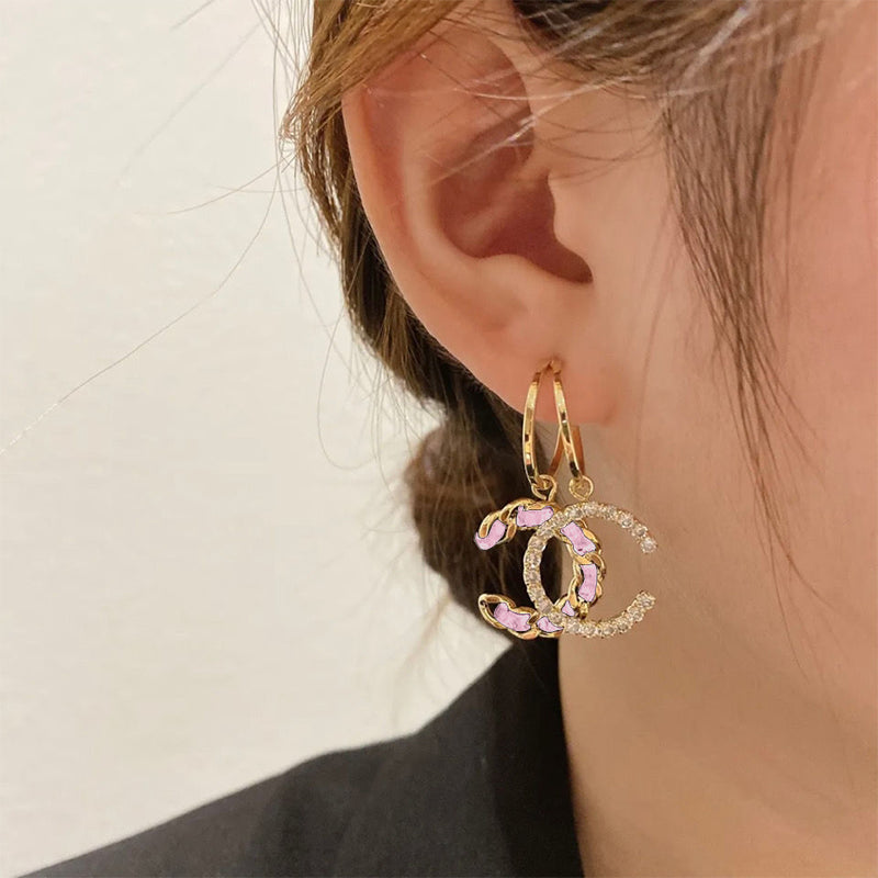 "Stilrena kvinnors silverörhängen med glittrande kristaller i dubbel 'C' design, eleganta och tidlösa accessoarer."