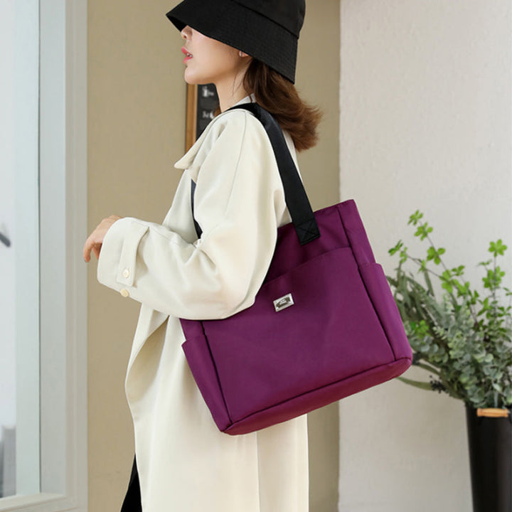 "Stor nylon damväska med flera fickor och dragkedja, svart färg, rymlig design, handtag 27 cm."