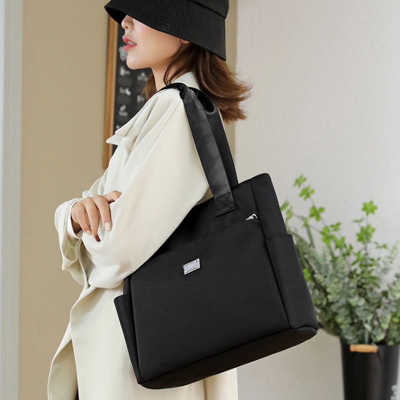 "Stor nylon damväska med flera fickor och dragkedja, svart färg, rymlig design, handtag 27 cm."