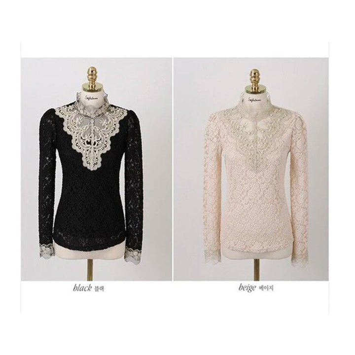 Elegant damblus i svart med spetsdetaljer och meshinsatser som ger en sofistikerad look.