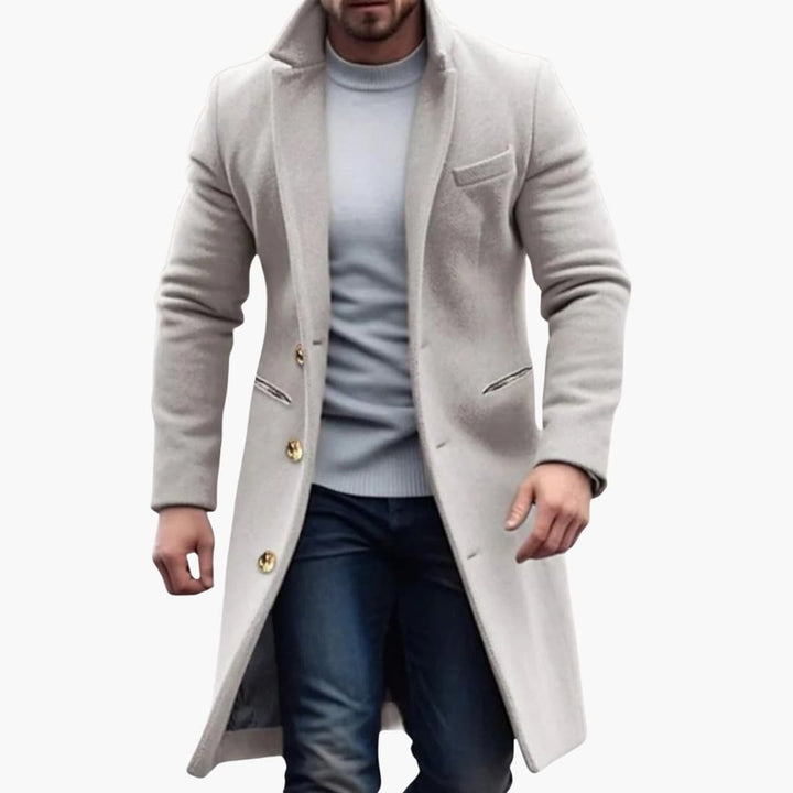 Khakifärgad herr långkappa med klassisk knappslå. Ett elegant och modernt ytterplagg för hösten.