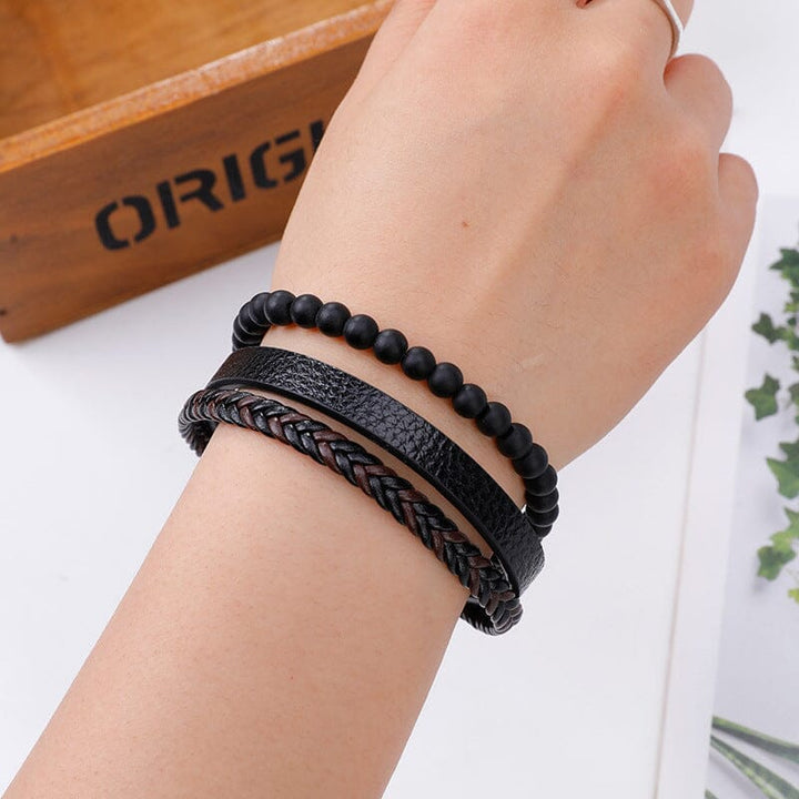 "Svart flätat läderarmband med hematitpärlor, stresslindrande och elegant accessoar för moderna män."