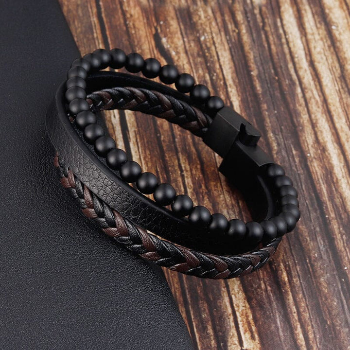 "Svart flätat läderarmband med hematitpärlor, stresslindrande och elegant accessoar för moderna män."