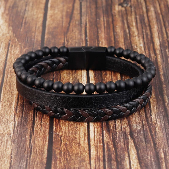 "Svart flätat läderarmband med hematitpärlor, stresslindrande och elegant accessoar för moderna män."