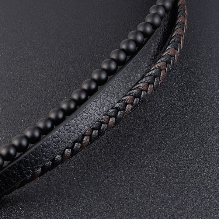 "Svart flätat läderarmband med hematitpärlor, stresslindrande och elegant accessoar för moderna män."
