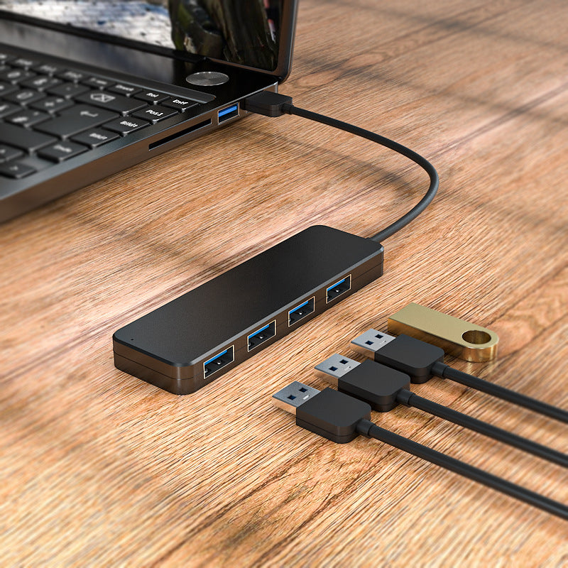 "Svart fyra-portars USB-dockningsstation med kompakt design, snabb USB 3.0-överföring, passar datorer och speltillbehör."