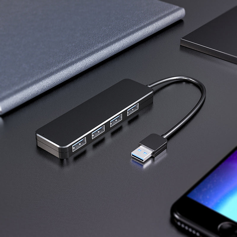 "Svart fyra-portars USB-dockningsstation med kompakt design, snabb USB 3.0-överföring, passar datorer och speltillbehör."