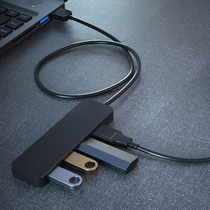 "Svart fyra-portars USB-dockningsstation med kompakt design, snabb USB 3.0-överföring, passar datorer och speltillbehör."