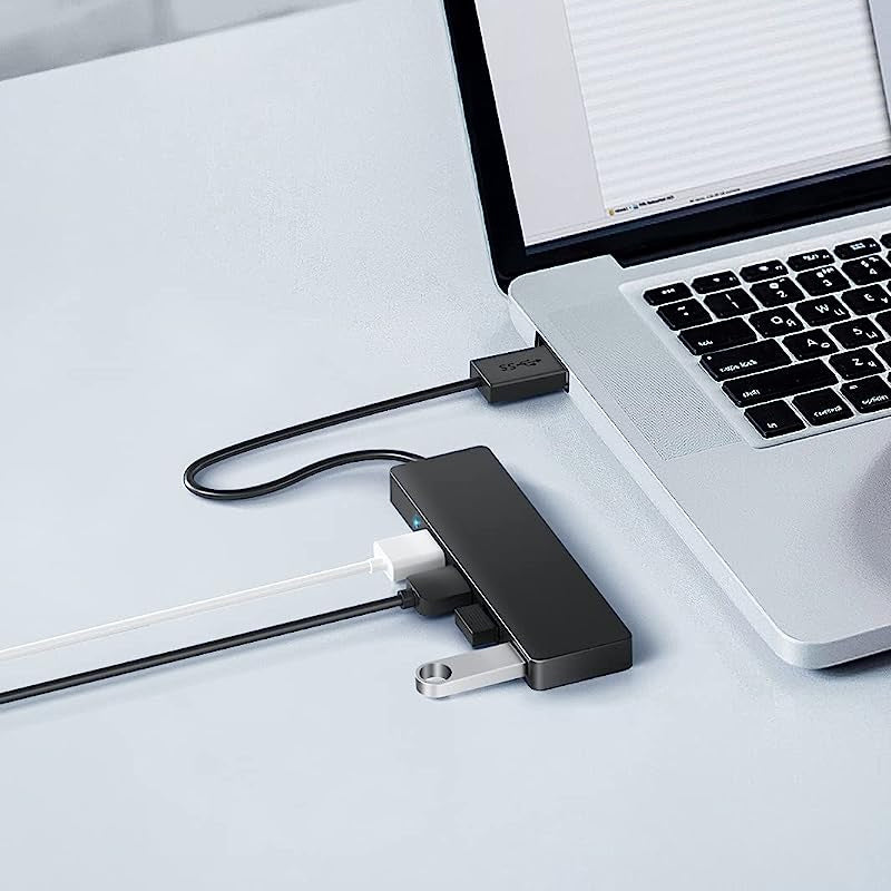 "Svart fyra-portars USB-dockningsstation med kompakt design, snabb USB 3.0-överföring, passar datorer och speltillbehör."