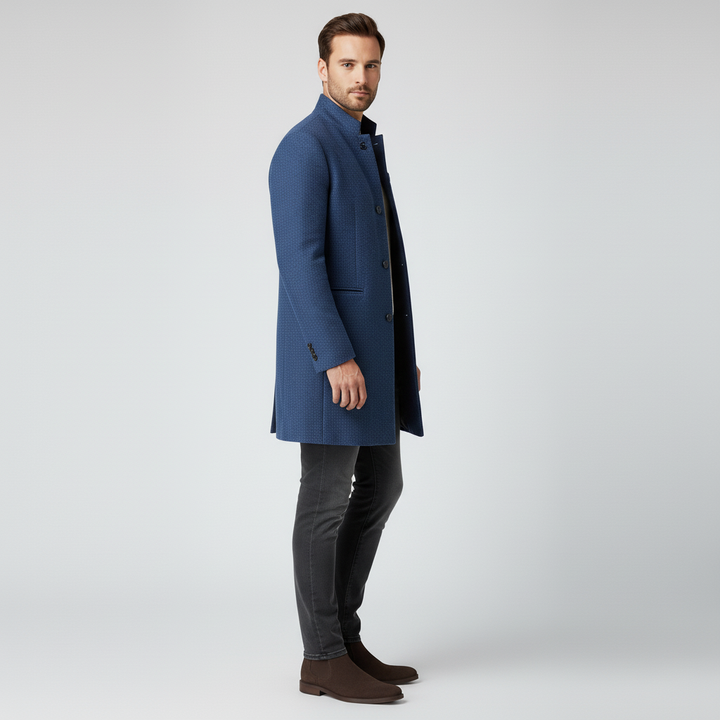 Man bär svart minimalistisk enkelknäppt långkappa. Elegant tidlös stil, perfekt herr-ytterplagg för mode.