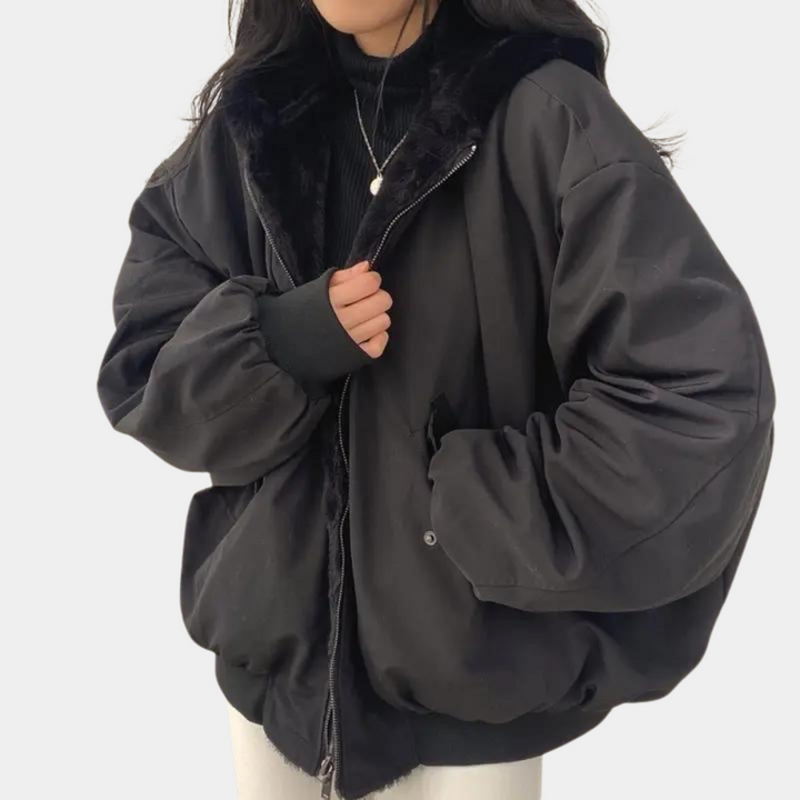 Modell som bär en varm och bekväm oversized lång vinterjacka för dam utomhus i vintermiljö.