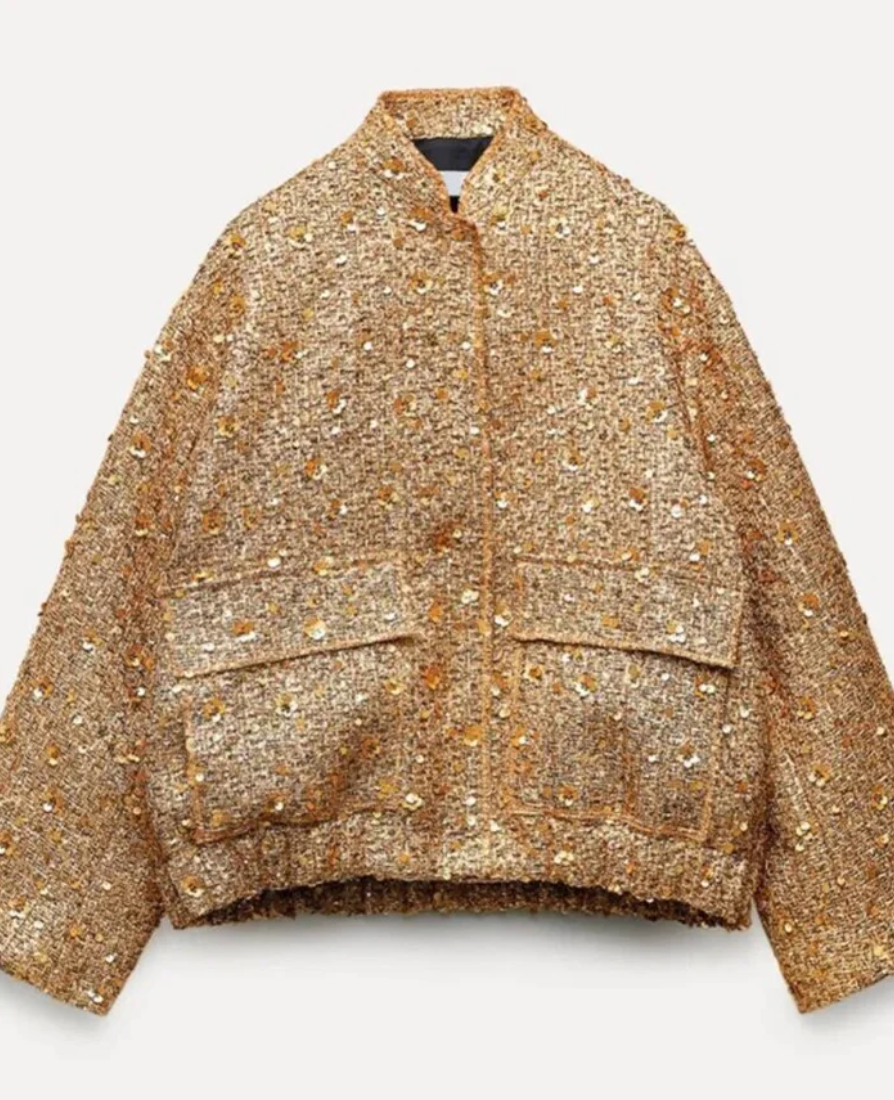 Närbild av gul paljettjackas ärm, visar glittrande paljetter och sömdetaljer för kvinnor.