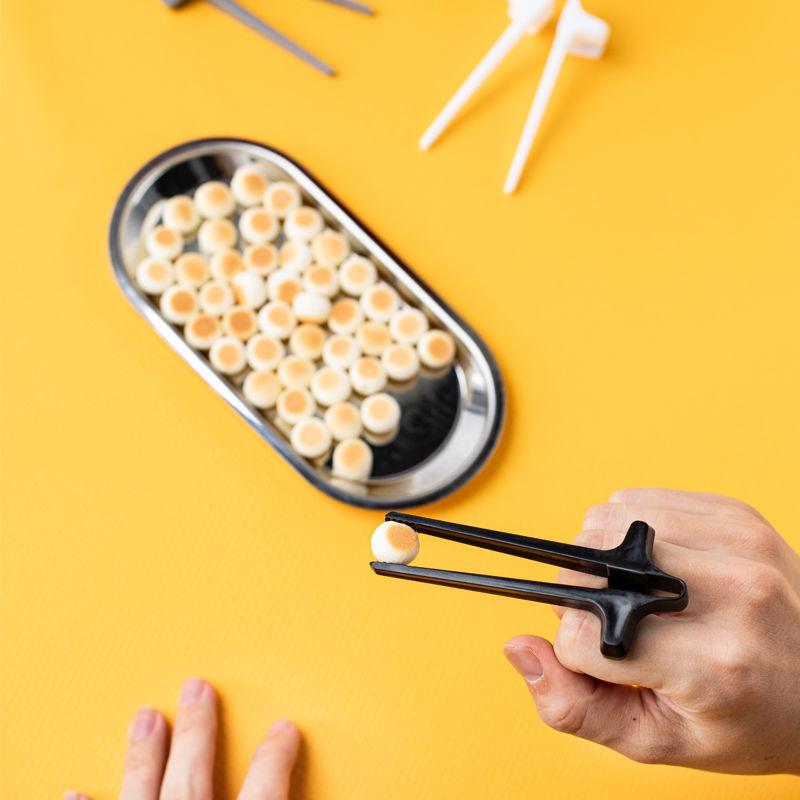 "Svart plastätpinne för snacks, innovativ design för rena händer och multitasking, perfekt för köket eller på språng."