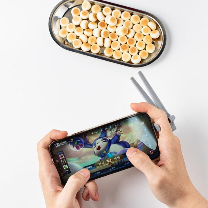 "Svart plastätpinne för snacks, innovativ design för rena händer och multitasking, perfekt för köket eller på språng."