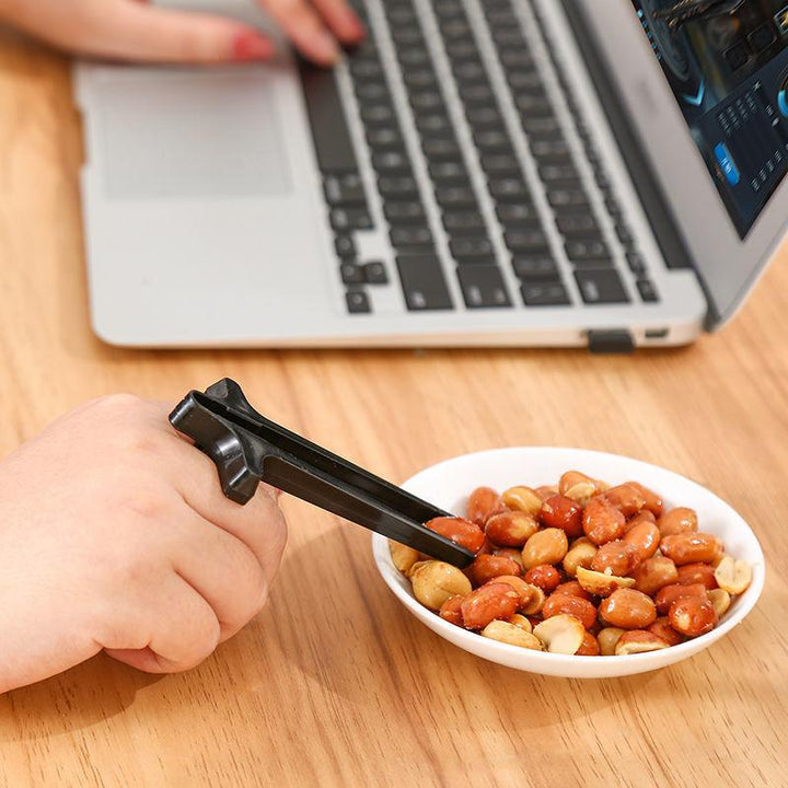 "Svart plastätpinne för snacks, innovativ design för rena händer och multitasking, perfekt för köket eller på språng."
