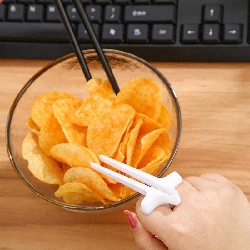 "Svart plastätpinne för snacks, innovativ design för rena händer och multitasking, perfekt för köket eller på språng."