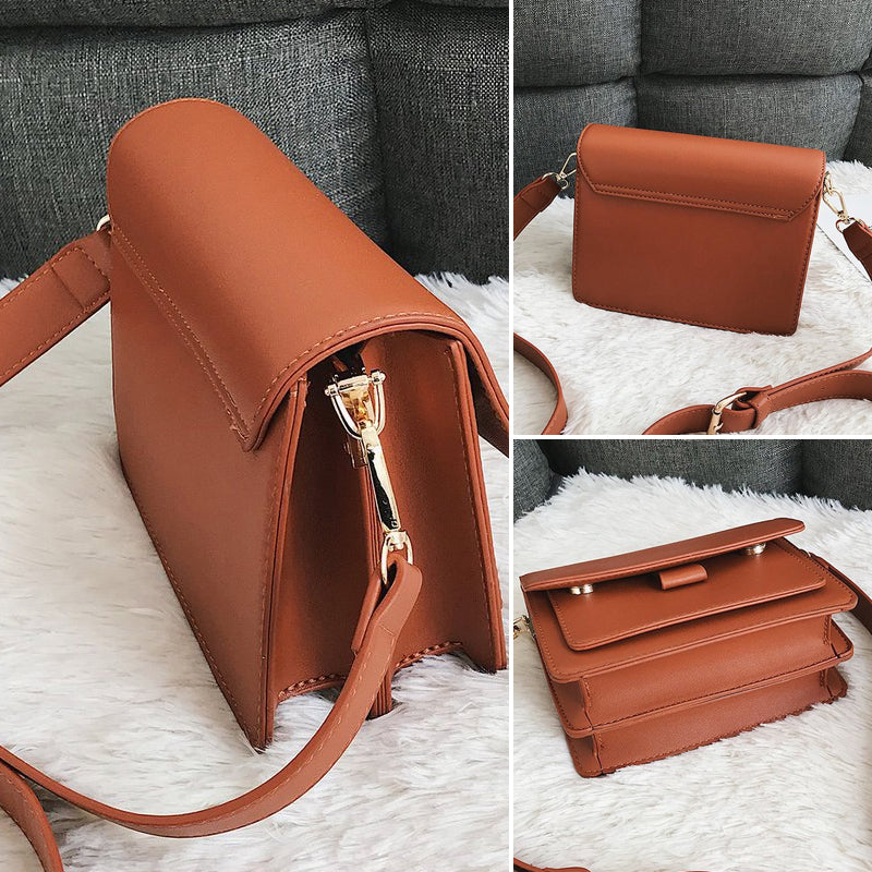 Svart retro crossbody väska i konstläder med minimalistisk design och flera fack för damaccessoarer.