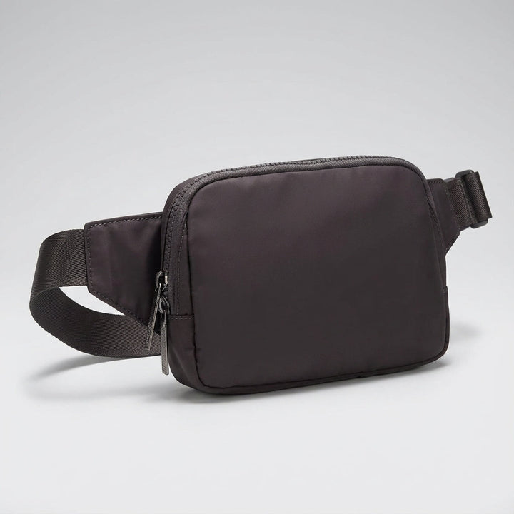 Grå organiserad nylon fannypack, idealisk som reseväska eller vardagsväska. Lätt och bekväm crossbodyväska.