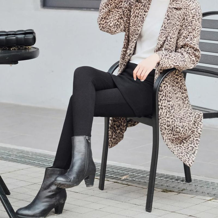 "Svarta fleecefodrade damkjolleggings, elegant och varm design, perfekt för vinterdagar, stilren matchning med stövlar."