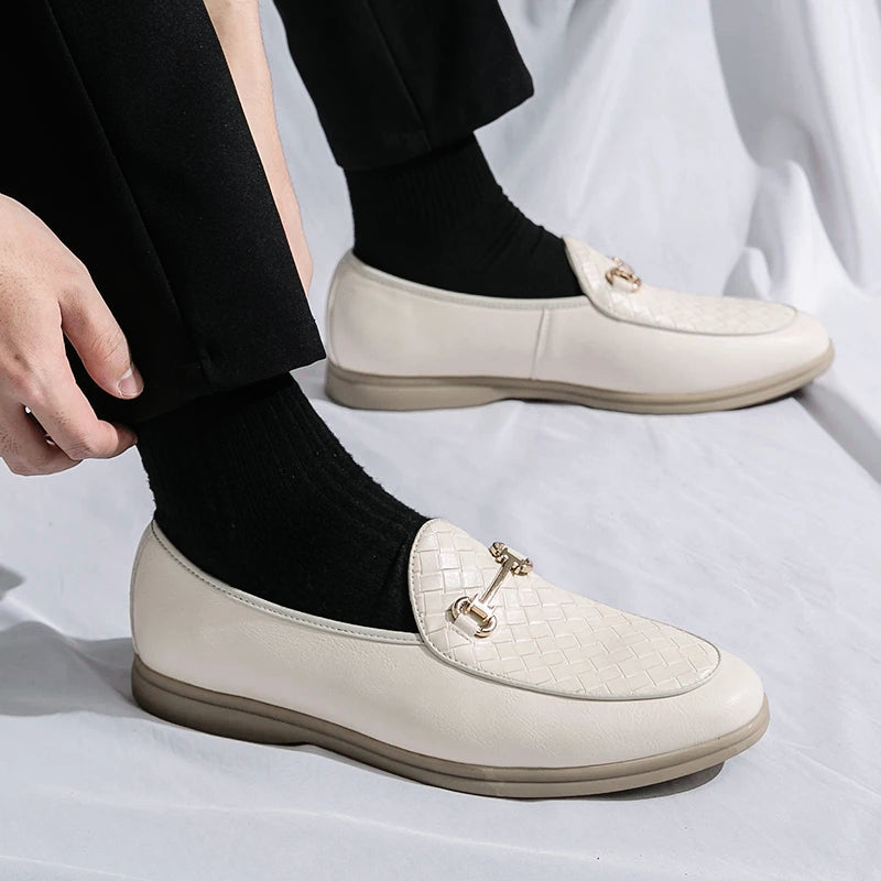 Stilrena beiga loafers för män, med distinkt vävd detalj och klassiskt hästbitsspänne, mångsidiga skor.