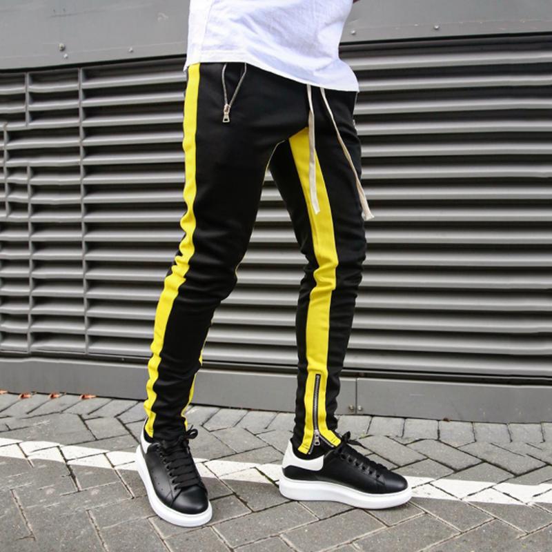 "Svarta herrjoggingbyxor med skinny passform, sidoficka med blixtlås, avsmalnande ben och mjukt polyestermaterial."