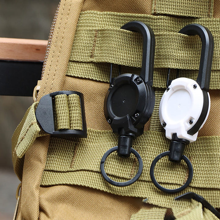 "Svart/vit multifunktionell nyckelring med infällbar vajer, hållbar aluminiumkarbin för utomhusbruk, ca 12,5 cm lång."