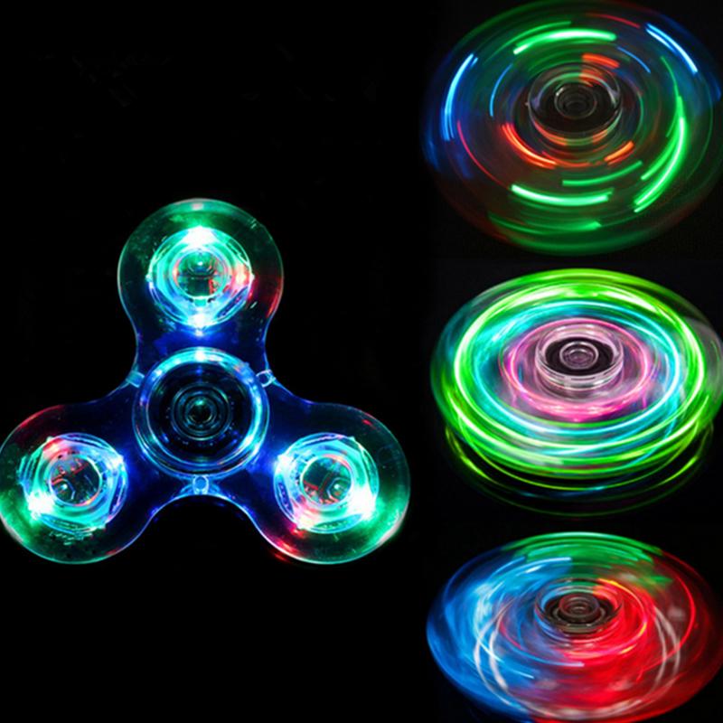 "Transparent LED fidget spinner med kristallklart material, blinkande lampor och snurrfunktion för stressavlastning."